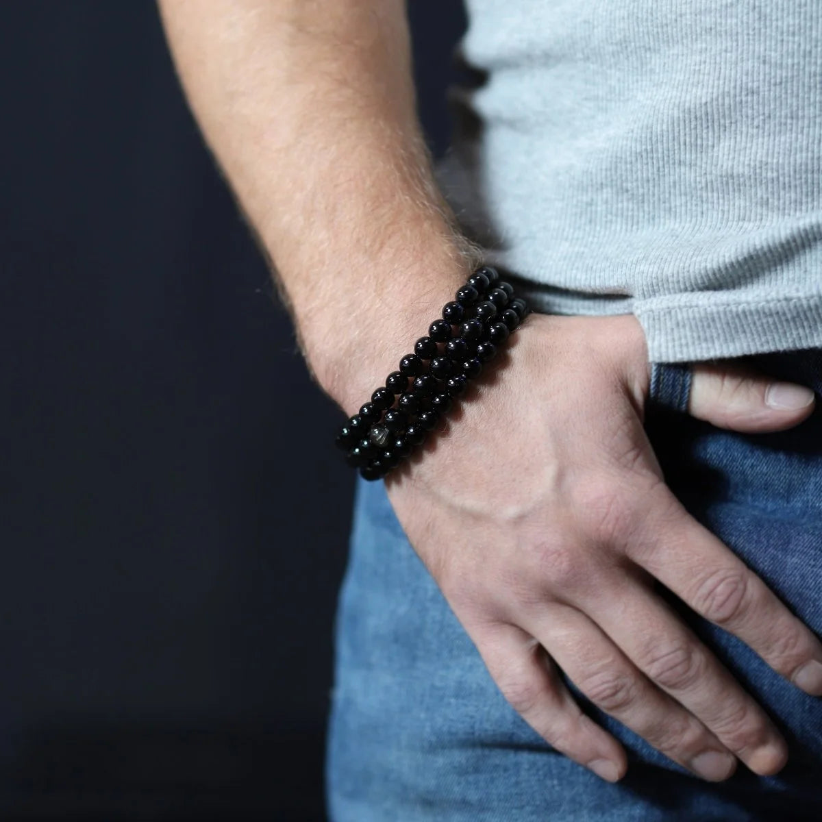 Black beaded bracelet worn on a person’s wrist.