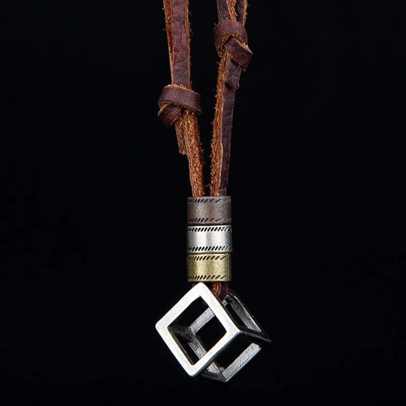 Leather necklace with a metallic cube-shaped pendant.