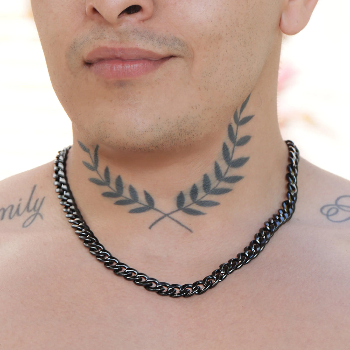 Neck tattoo of crossed olive branches forming a laurel wreath shape.