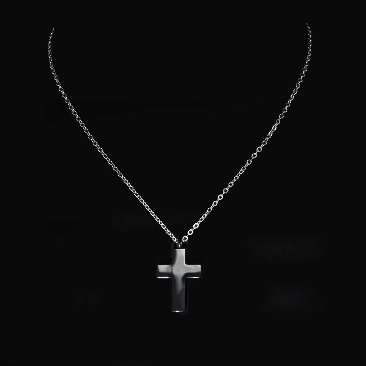 Silver cross pendant on a delicate chain necklace.