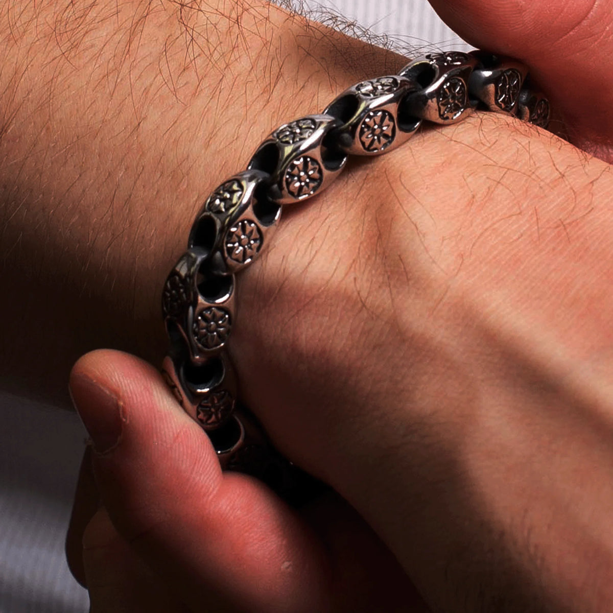 Ornate black metal bracelet with intricate floral or circular designs on each link.