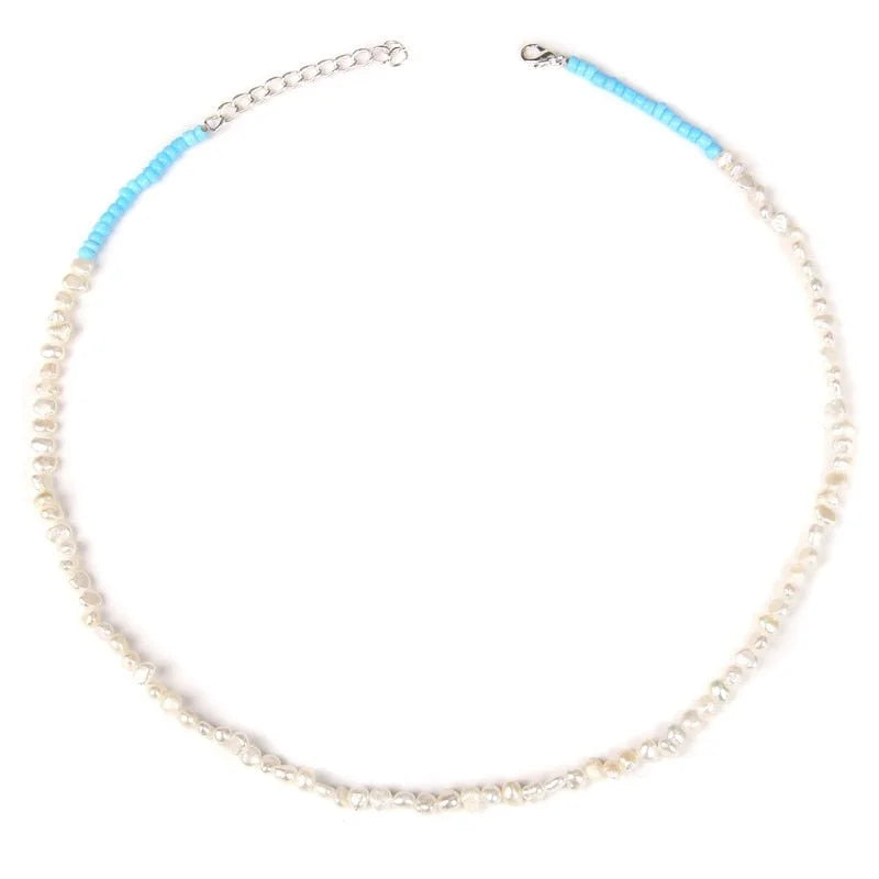 Delicate beaded necklace with white pearls and turquoise accents.