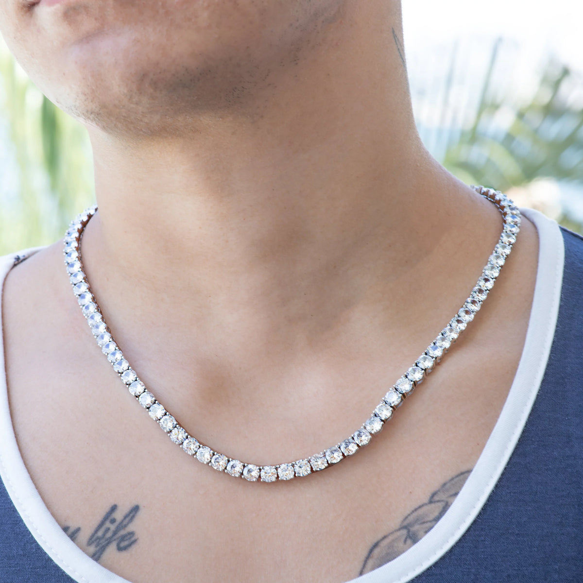 Diamond tennis necklace worn around a person’s neck.