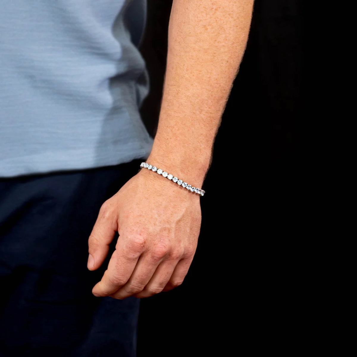 Diamond tennis bracelet worn on a wrist.