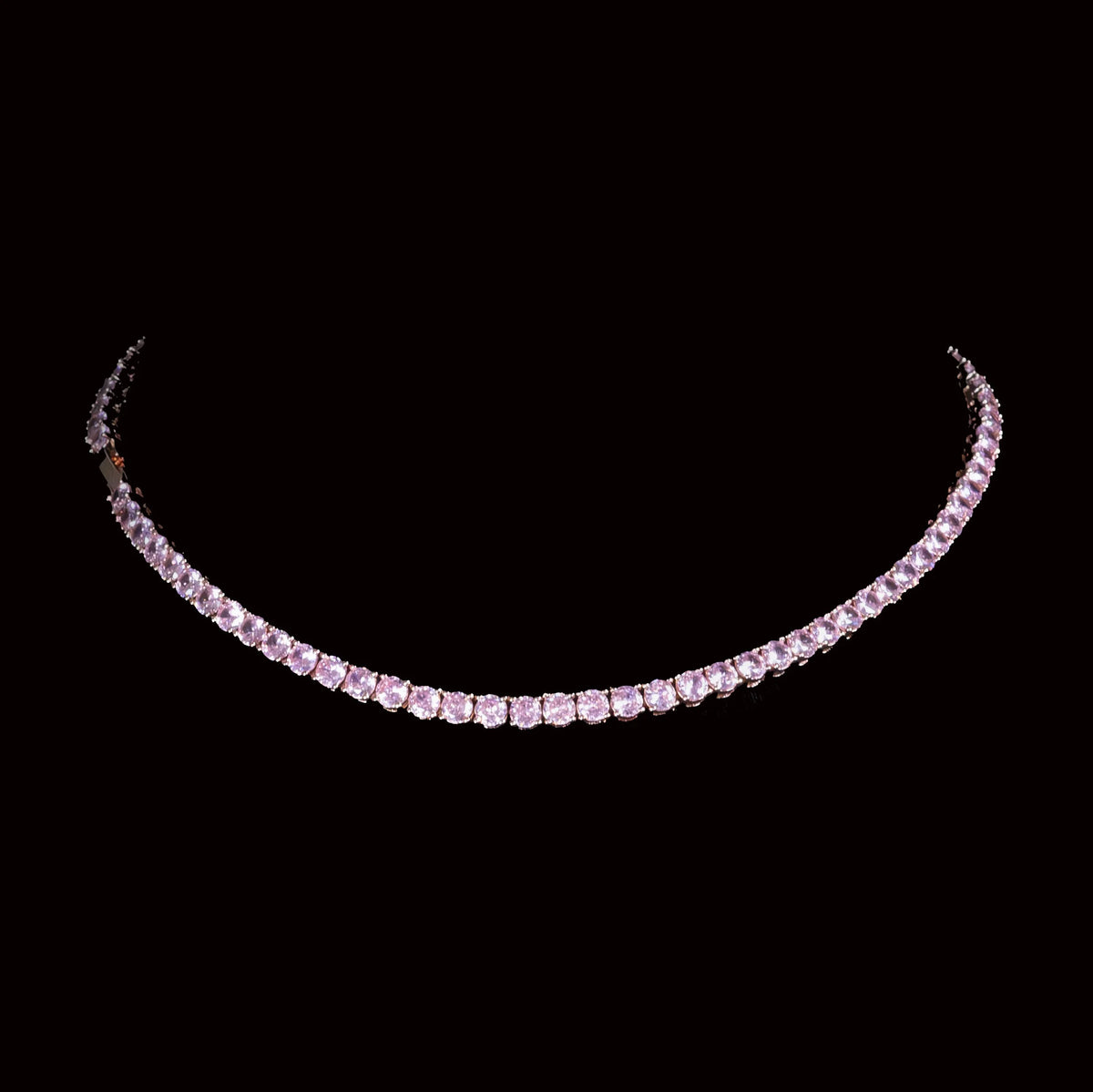 Elegant diamond or crystal necklace with pink gemstones set in a curved line.