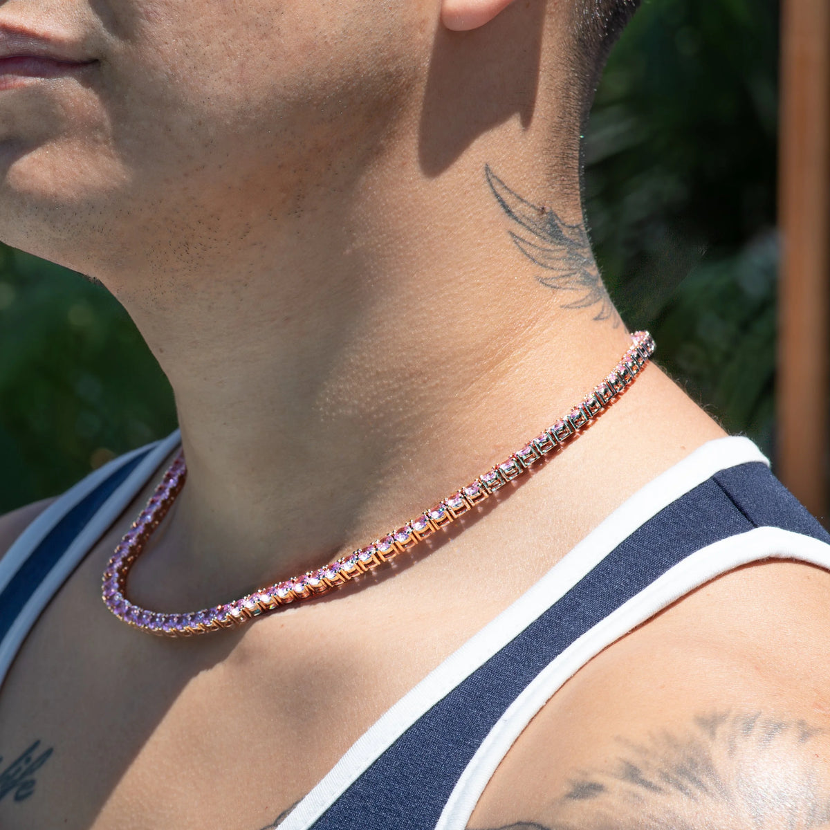 Sparkling pink gemstone tennis necklace worn around a neck.