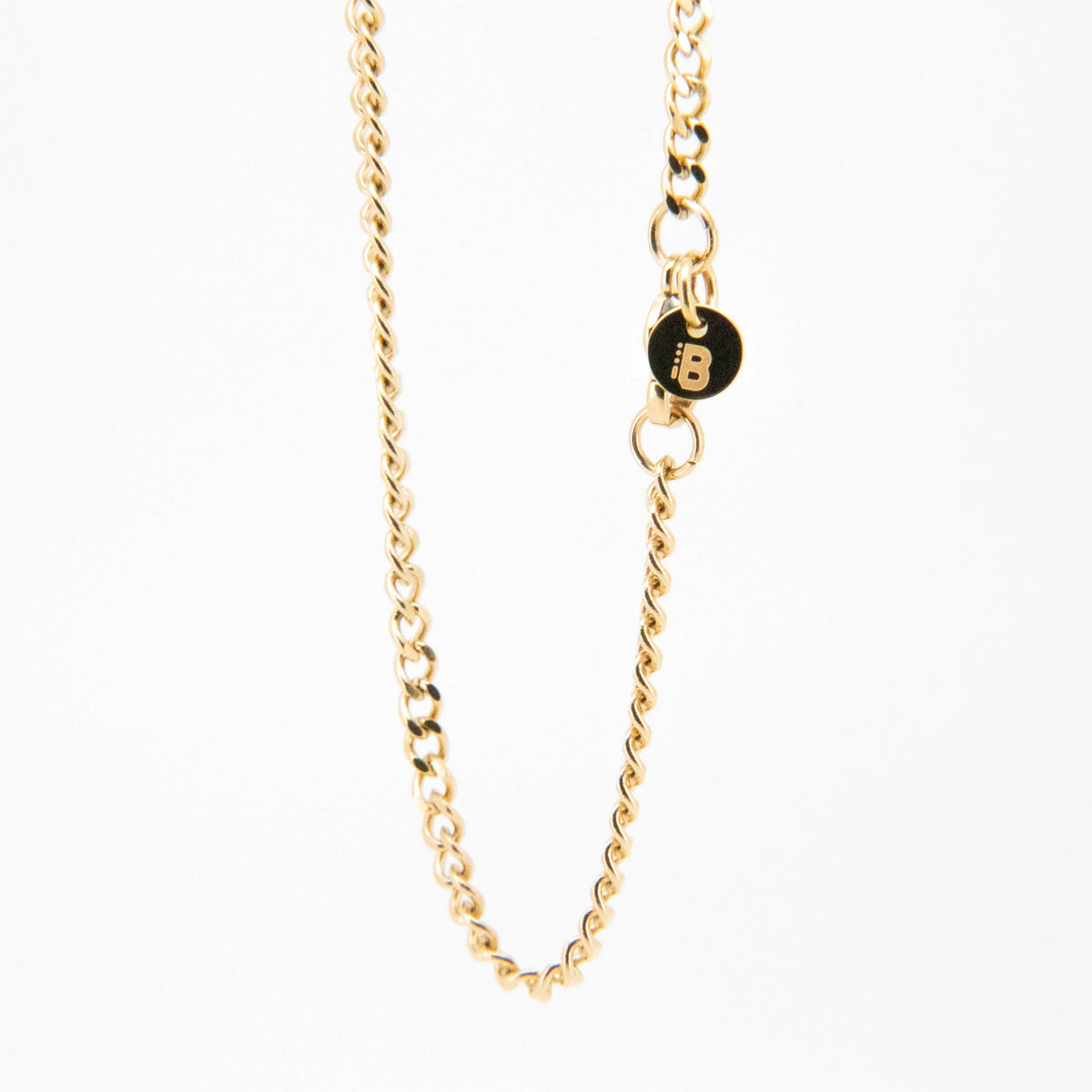 Gold-toned chain necklace with a small black circular charm.