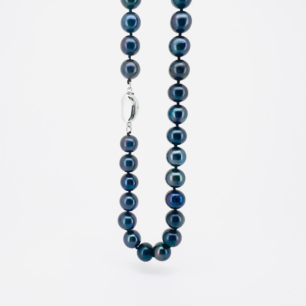 Pearl necklace with dark blue-gray pearls and a silver clasp.