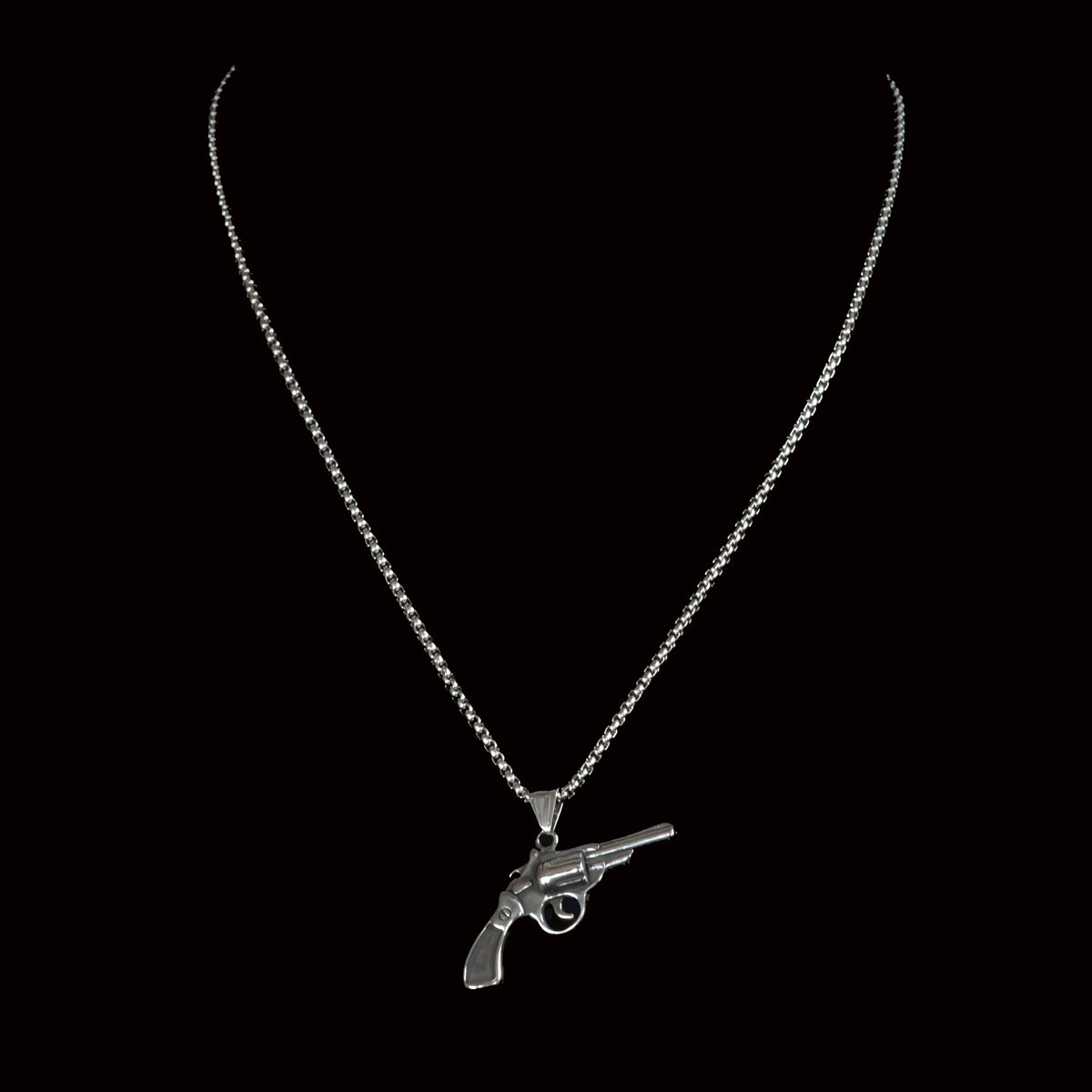 Silver necklace with a revolver-shaped pendant.