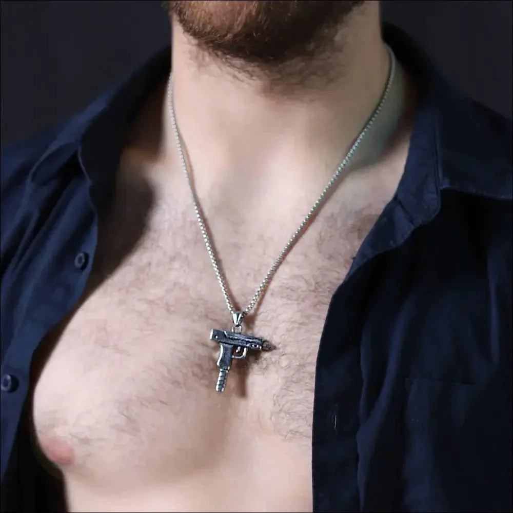 Gun-shaped pendant necklace worn around a person’s neck.