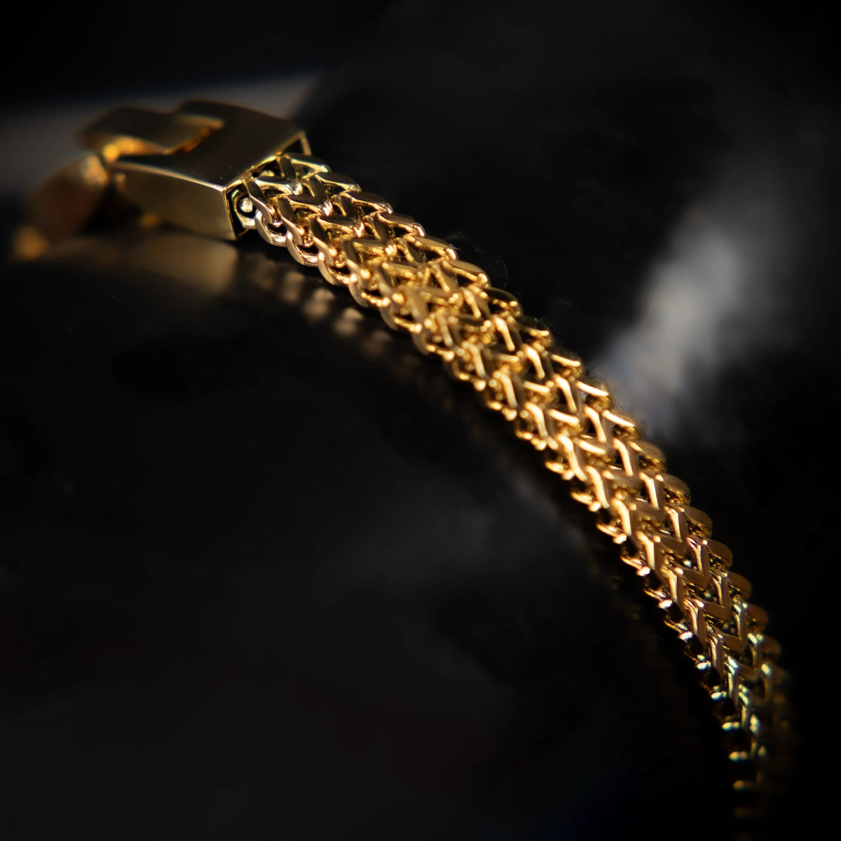 Gold bracelet with an intricate woven chain design.