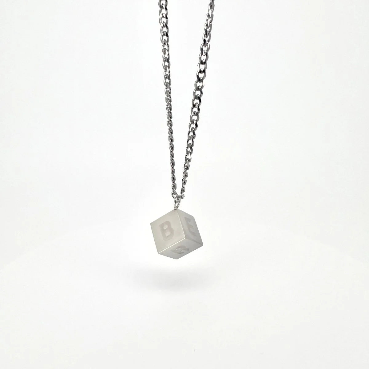 Cube-shaped pendant with the number 8 engraved on it, hanging from a silver chain necklace.