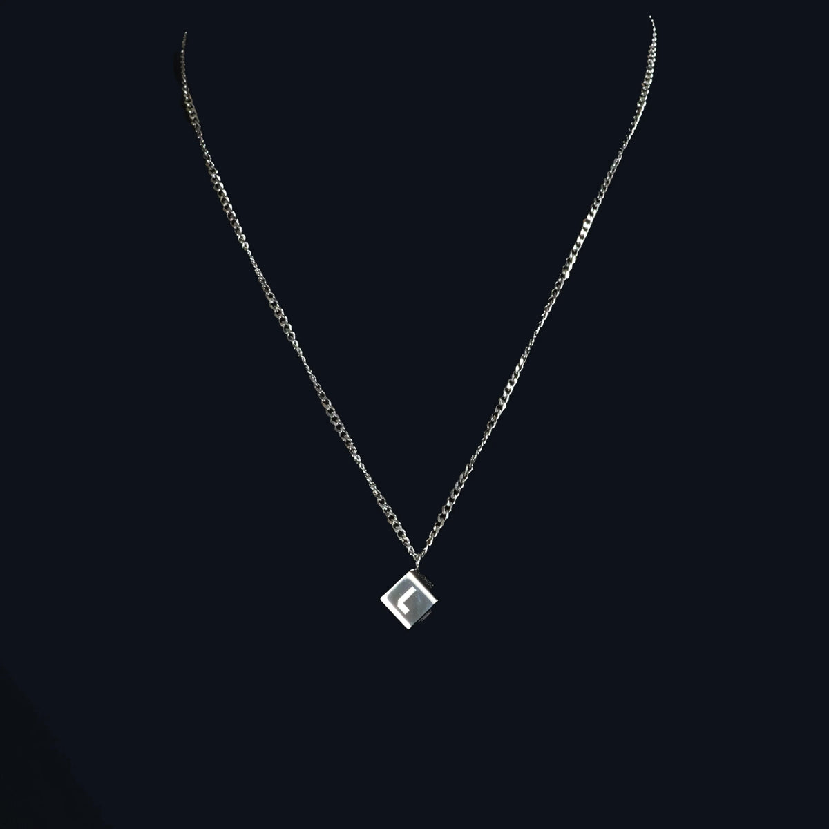 Silver necklace with a square pendant featuring the letter ’F’.