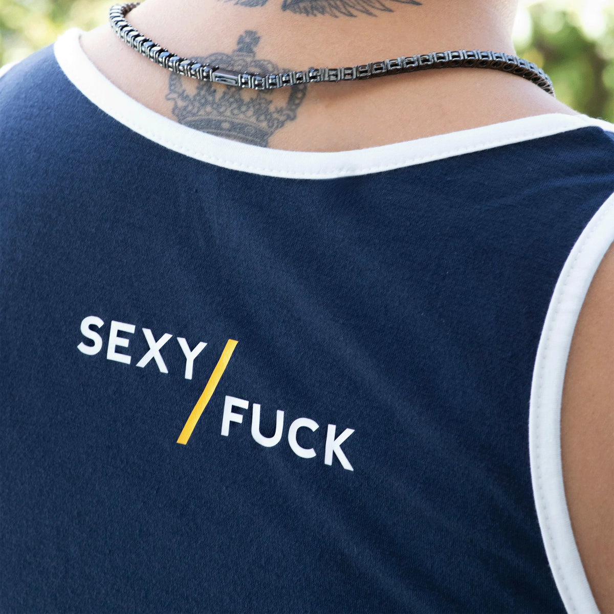 Navy blue tank top with white trim and provocative text printed on it.