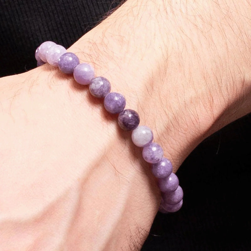 Purple and lavender beaded bracelet worn on a wrist.