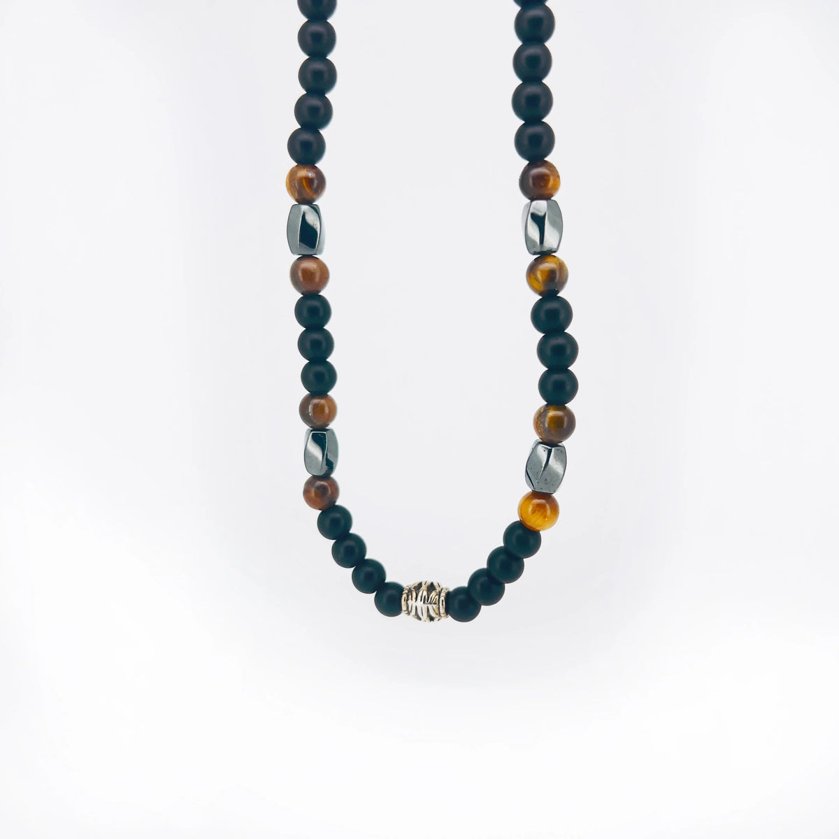 Beaded necklace with black, brown, and metallic spheres arranged in a pattern.