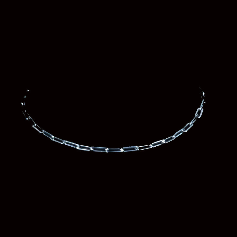 Curved metal chain with elongated links against a black background.