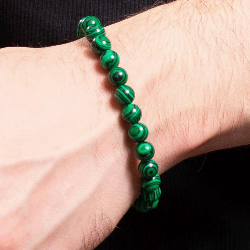 Green malachite bead bracelet worn on a wrist.