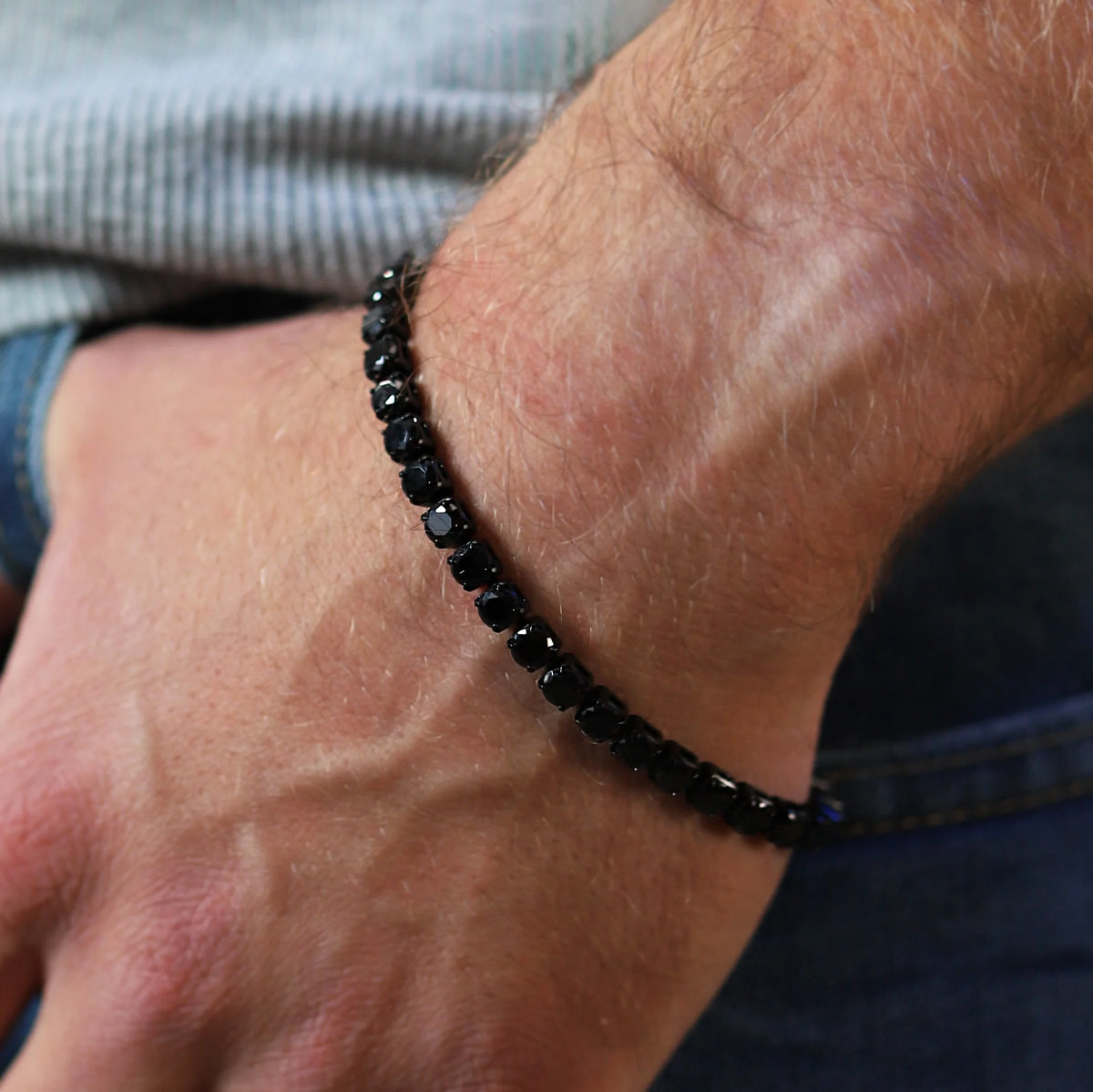 Black beaded bracelet worn on a wrist.