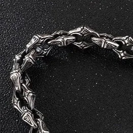 Intricately designed silver chain bracelet with a gothic or tribal-inspired pattern.