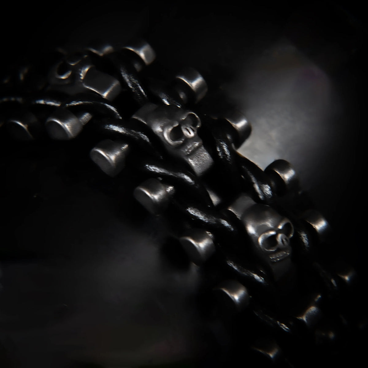 Dark metallic chain with skull-shaped links.