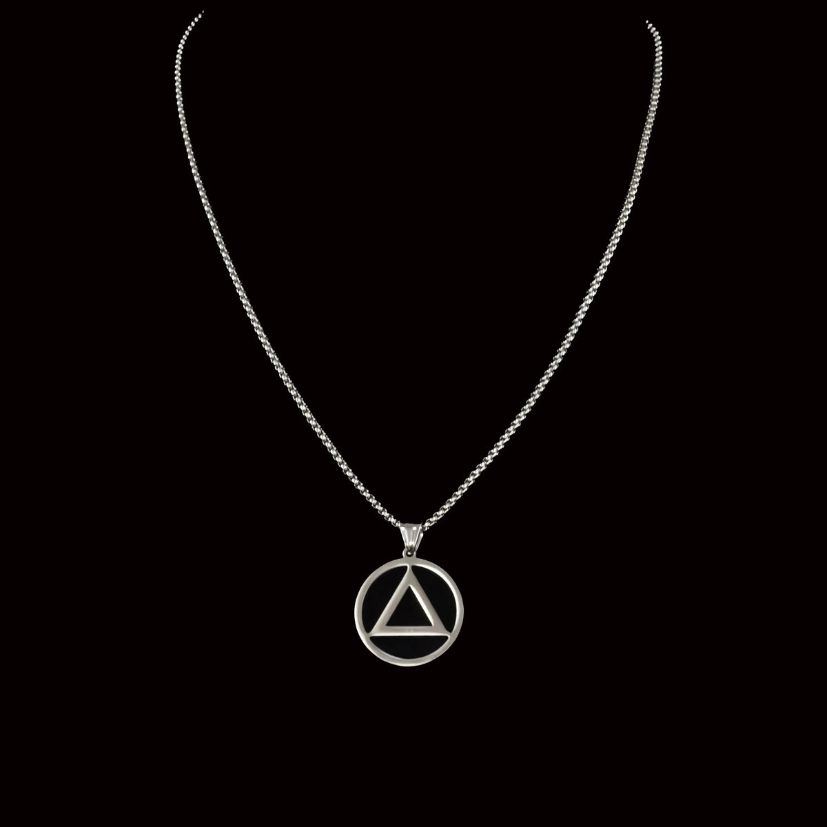 Silver necklace with a circular pendant containing a triangle symbol.