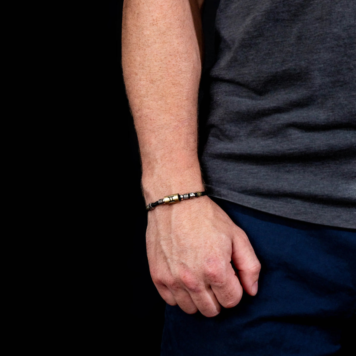 Black and gold beaded bracelet worn on a wrist.