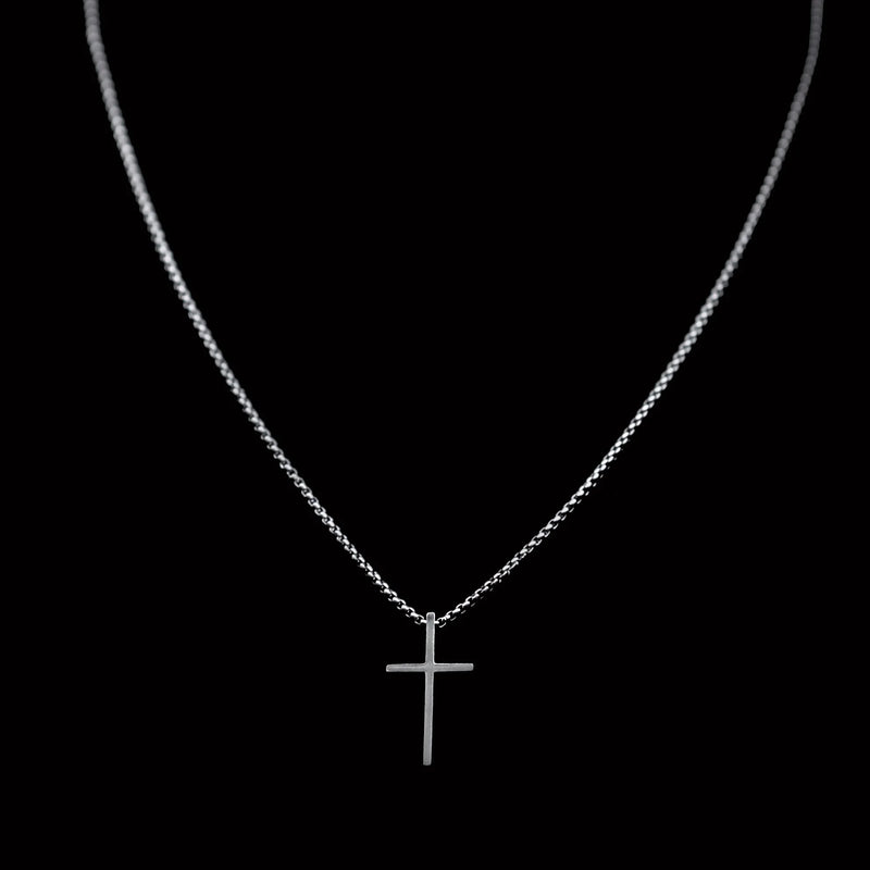 Silver cross pendant on a delicate chain necklace.