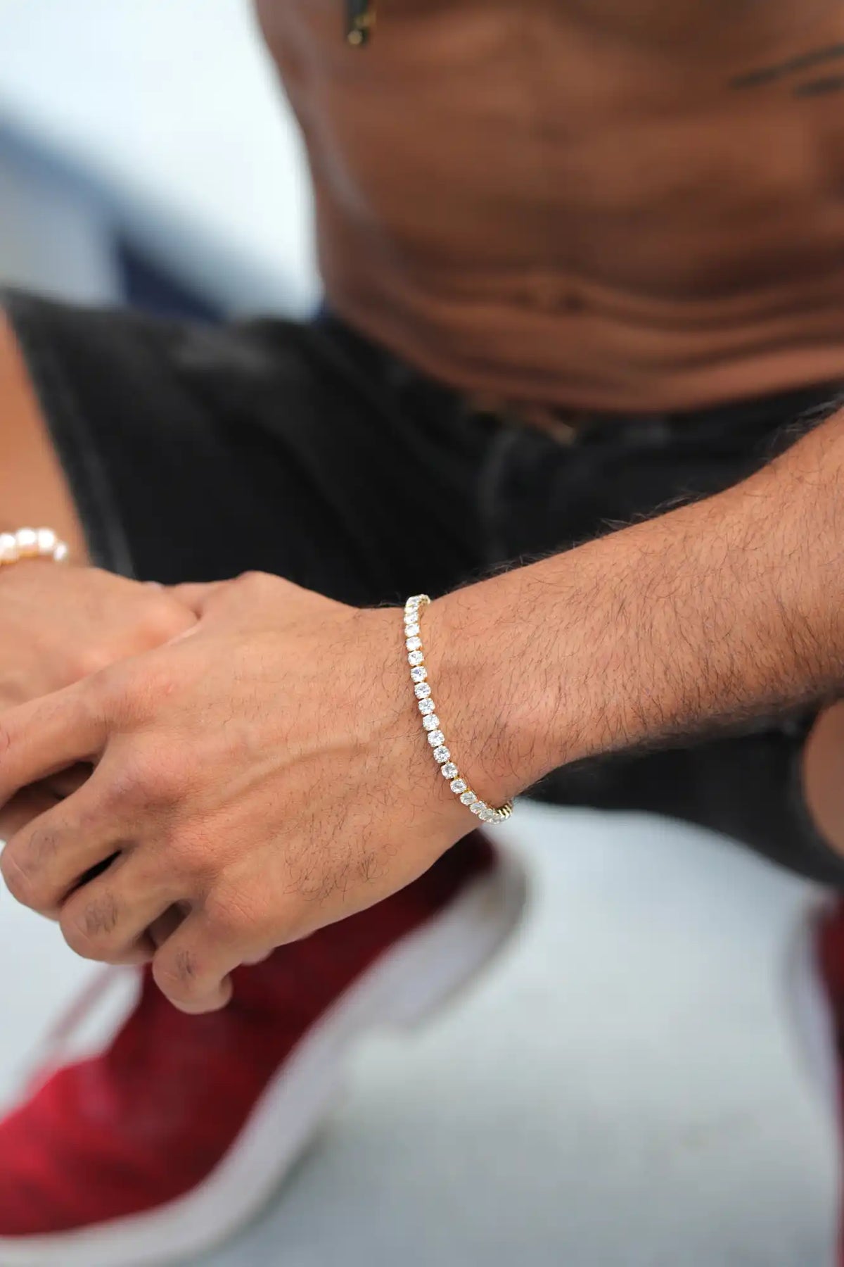 Sparkling diamond tennis bracelet worn on a wrist.