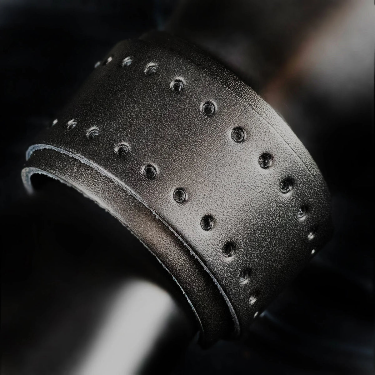 Black leather cuff bracelet with metal studs or rivets.