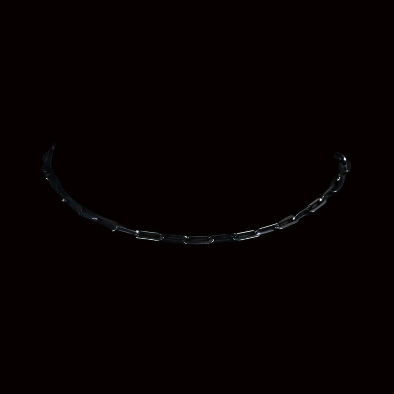 Curved metal chain or bracelet with rectangular links against a dark background.