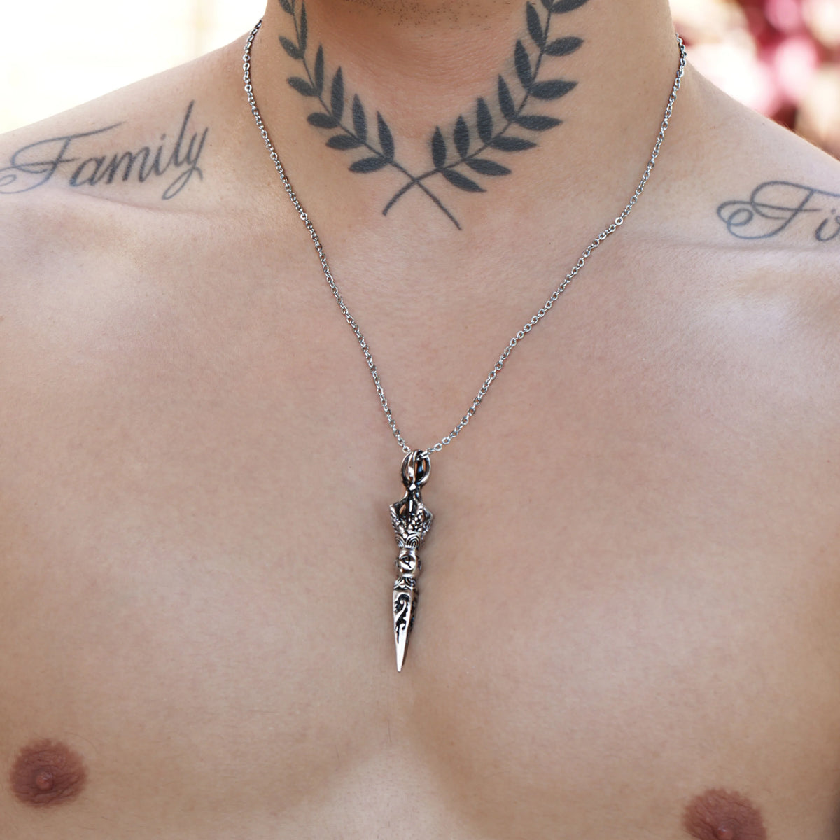 Silver dagger pendant necklace with decorative handle design.