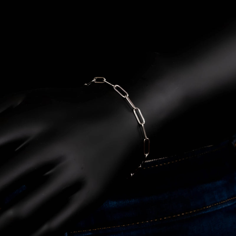 Silver chain bracelet against a dark surface.