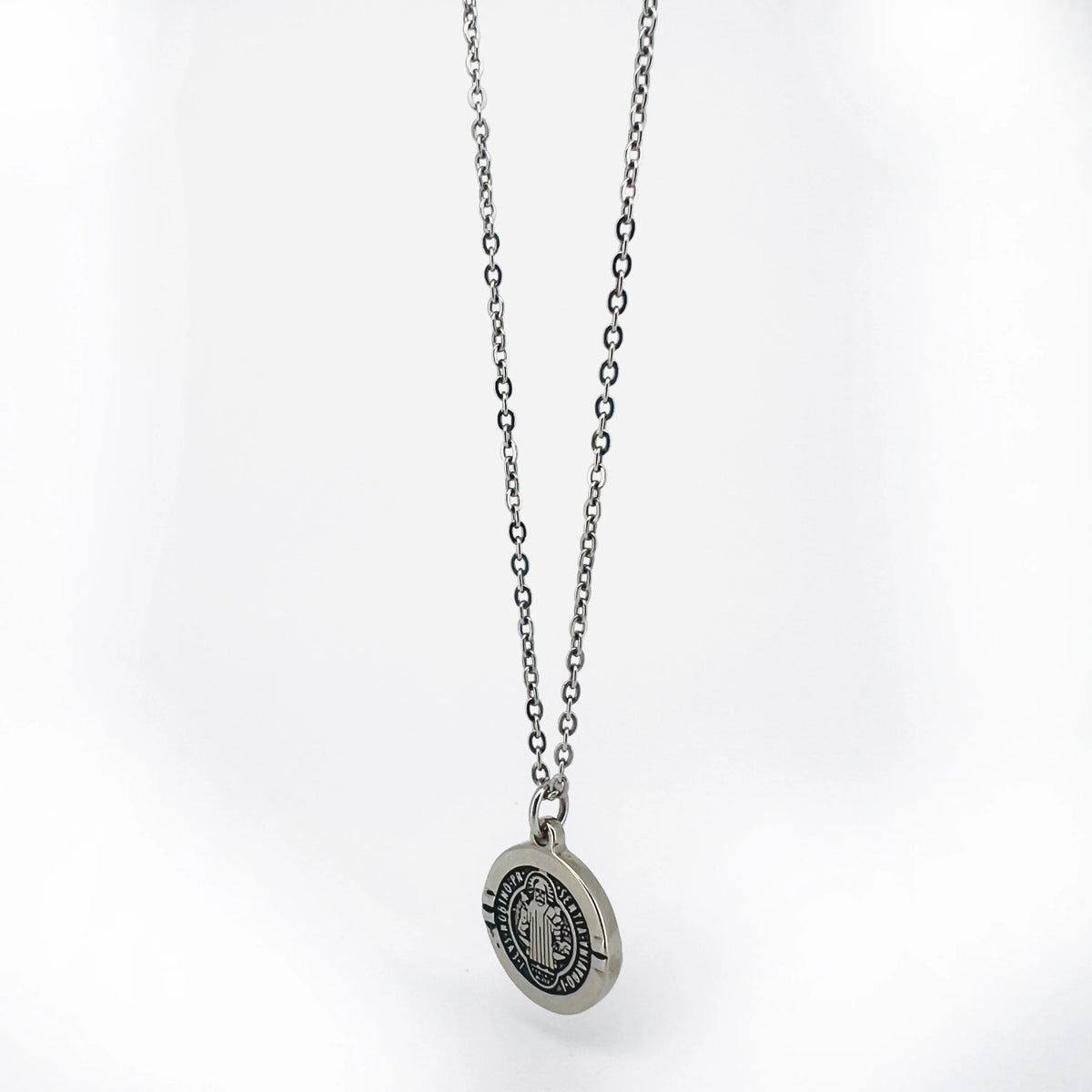 Silver pendant necklace with a circular medallion charm.