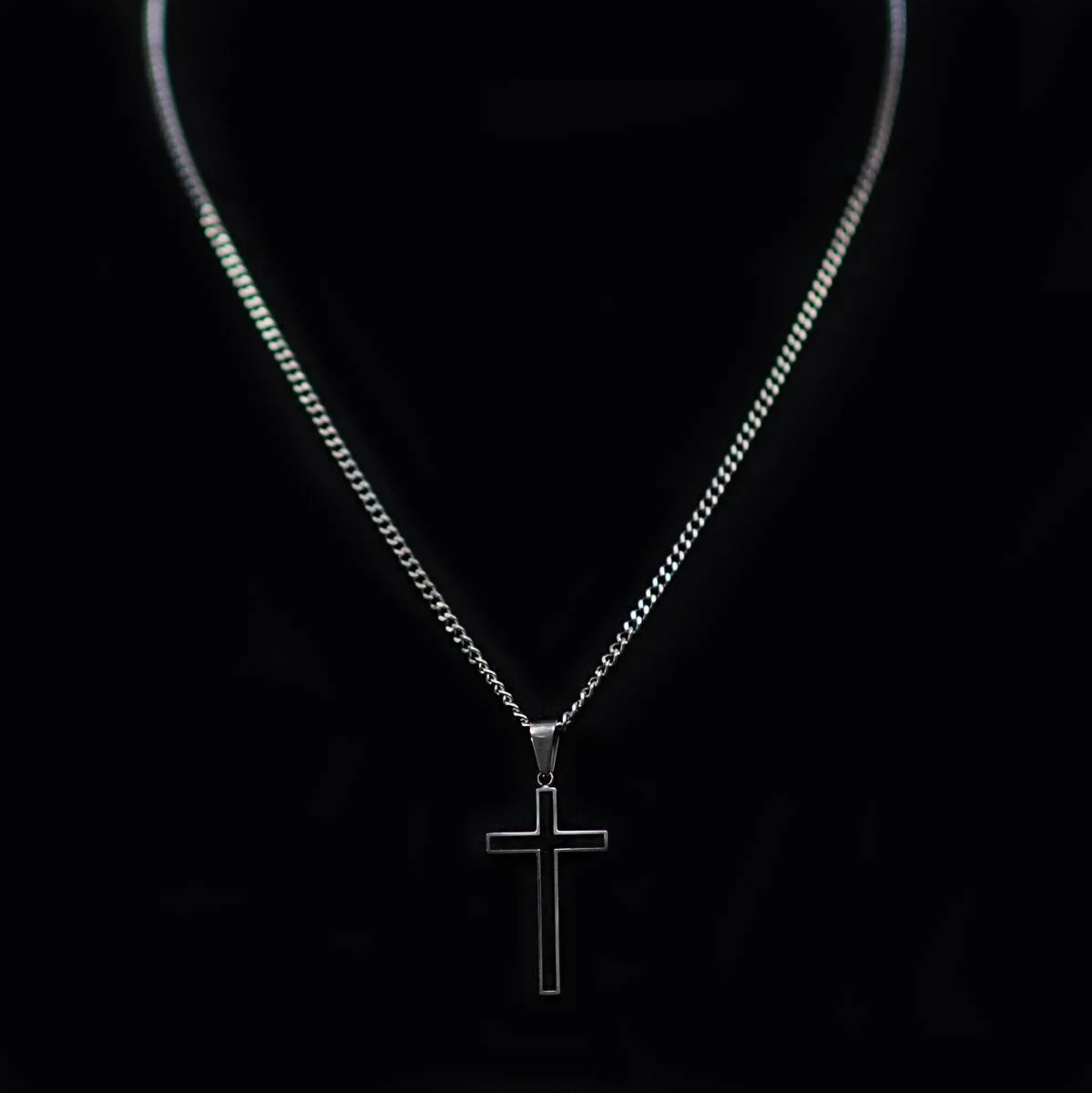 Silver cross pendant necklace on a thin chain.