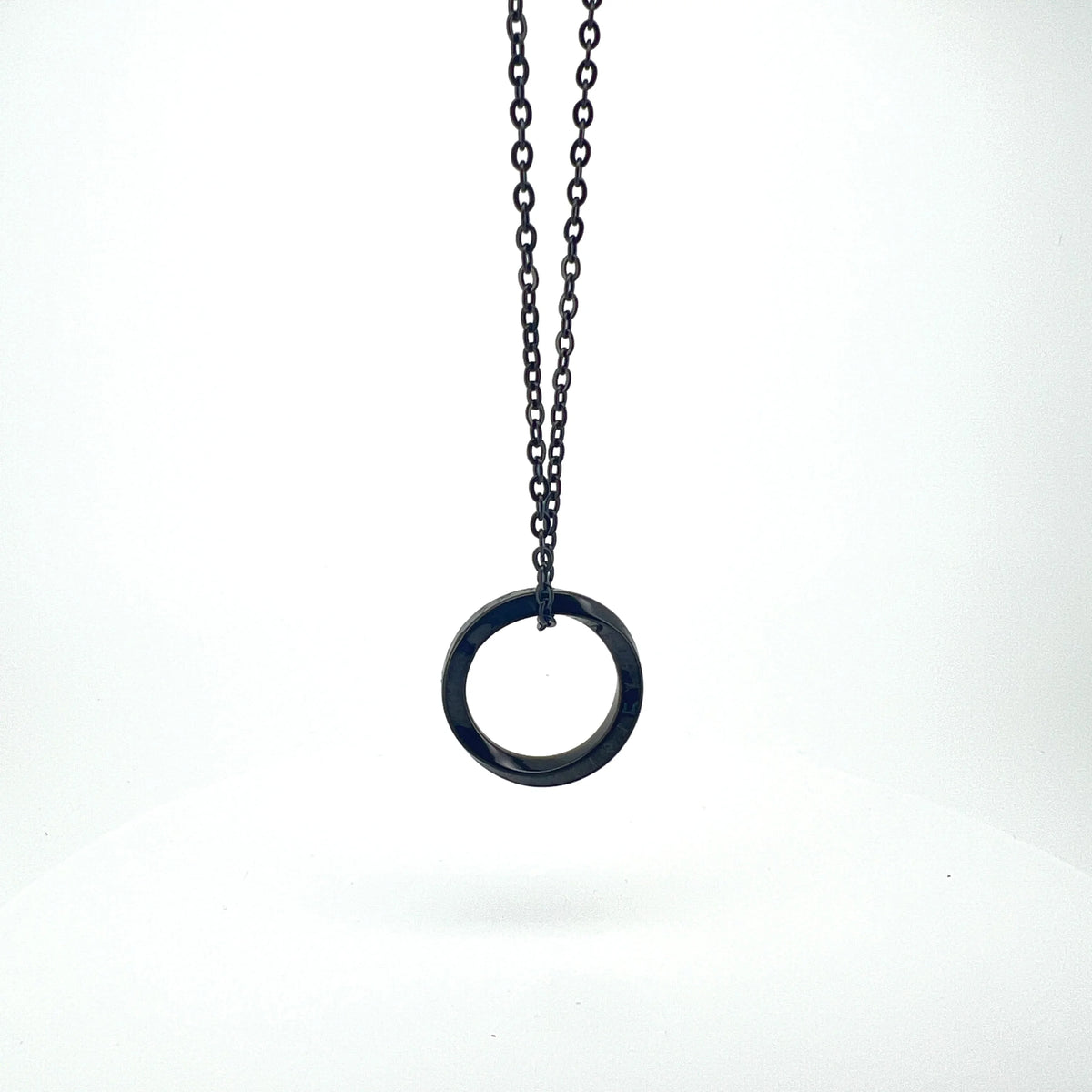 Circular pendant hanging from a black chain necklace.