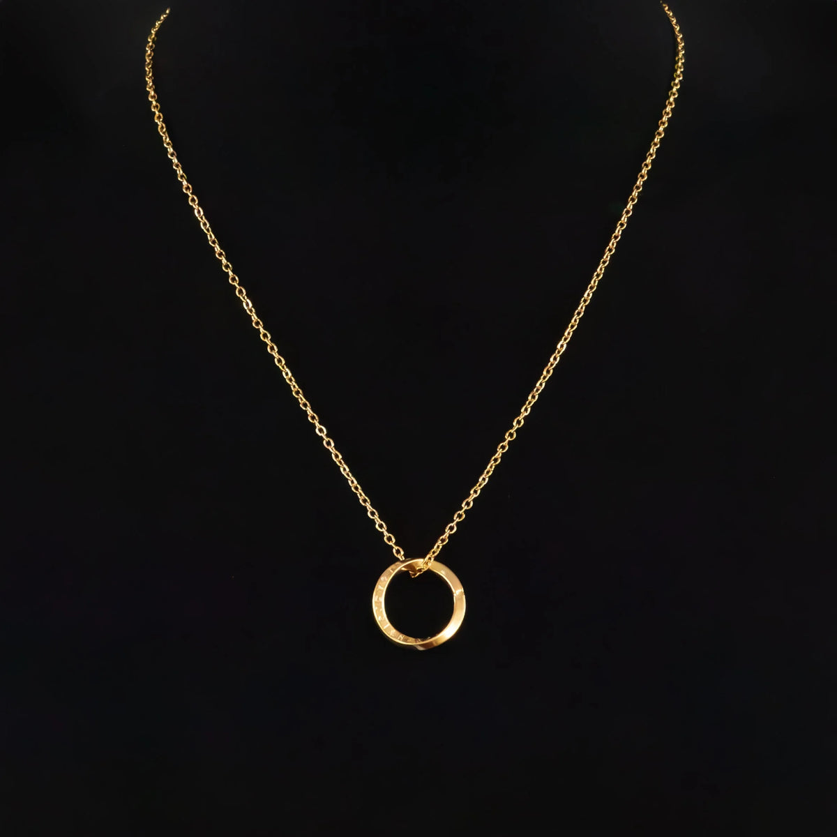 Gold necklace with a circular pendant.