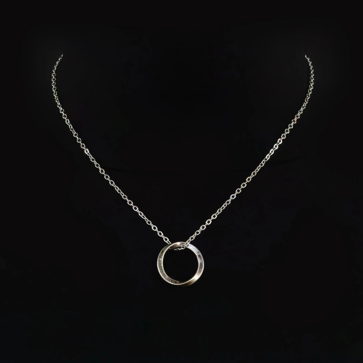 Silver necklace with a circular pendant.