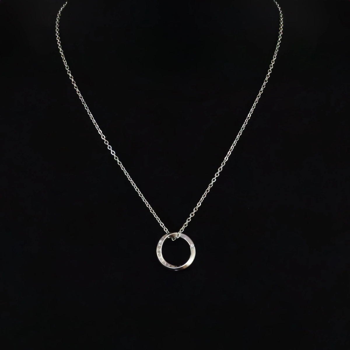 Silver necklace with a circular pendant.