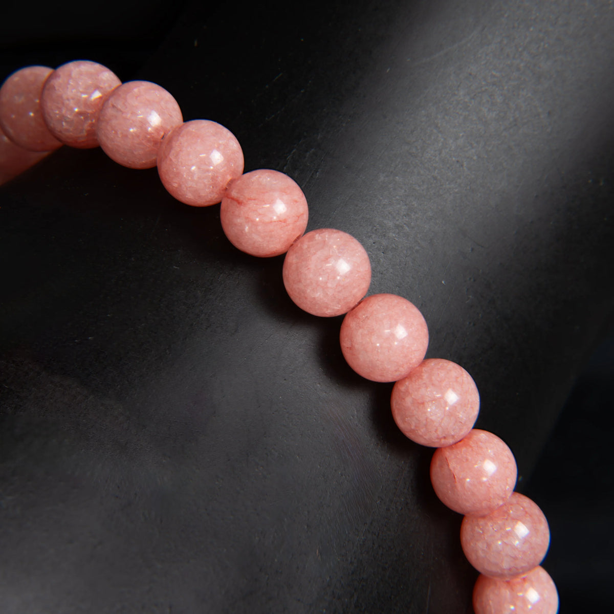 String of pink, spherical beads with a smooth, polished appearance.