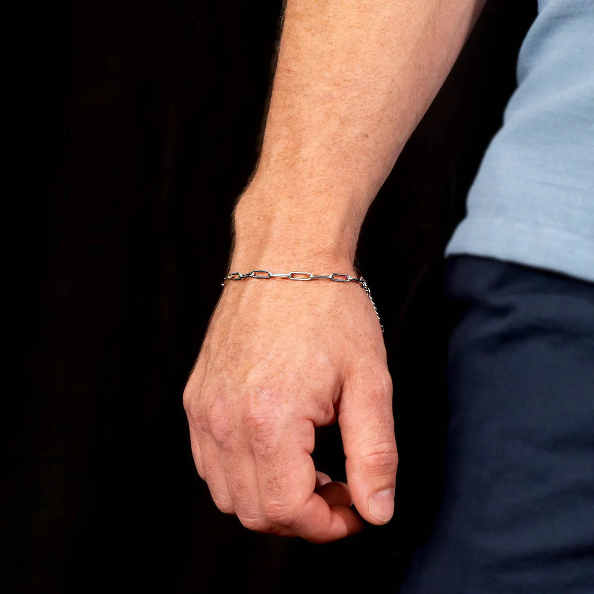 Silver chain bracelet worn on a wrist.