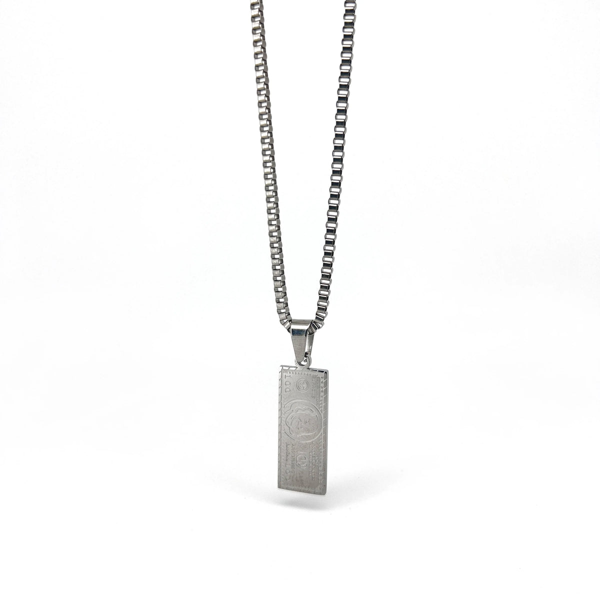 Silver pendant necklace with a rectangular charm featuring an engraved design.