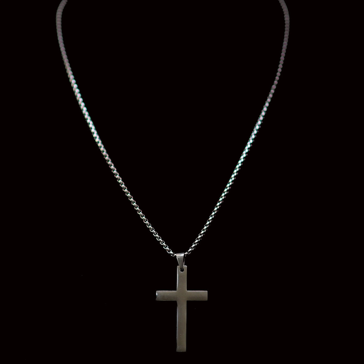 Silver cross pendant necklace on a thin chain.