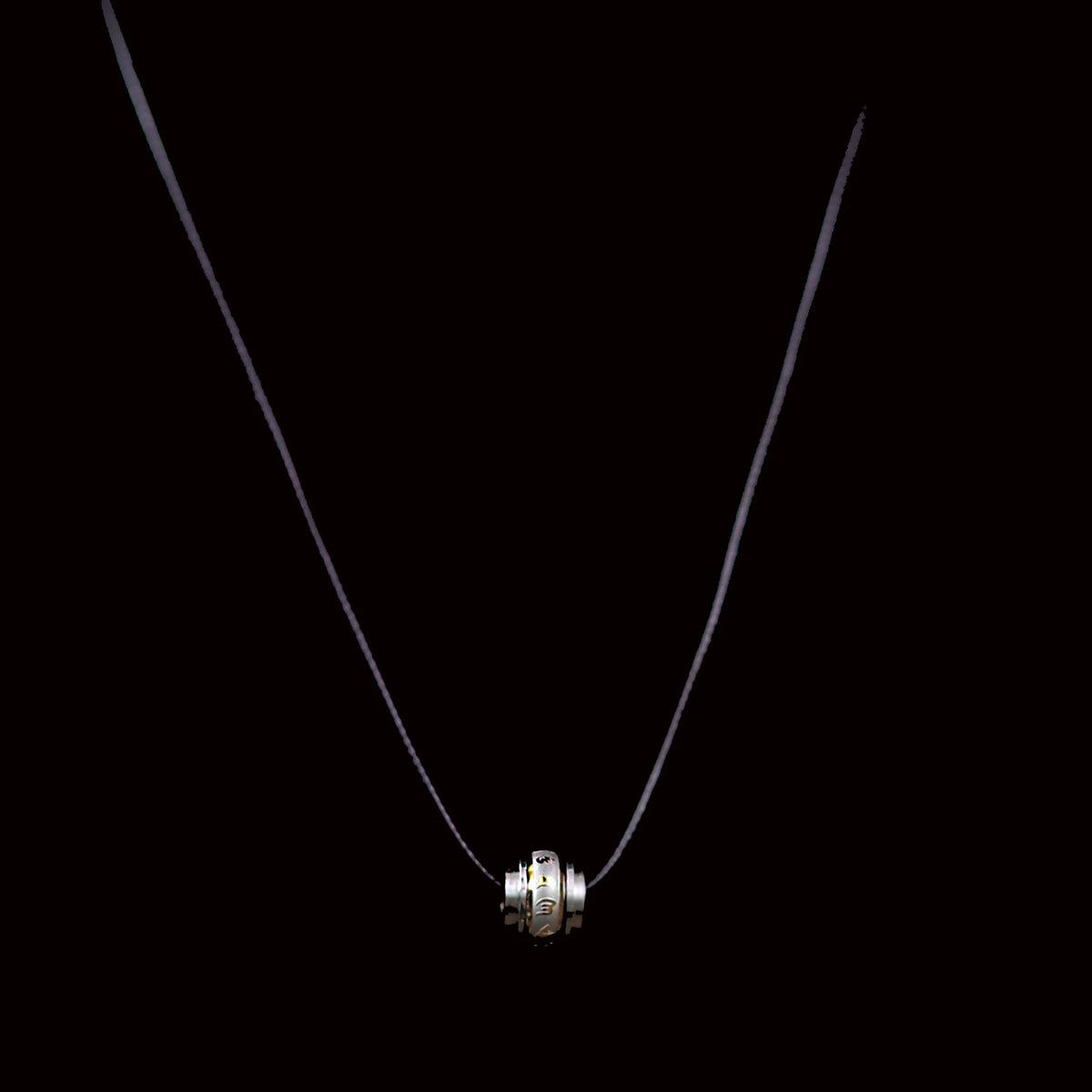 Silver pendant necklace with a cylindrical charm featuring ridged edges.