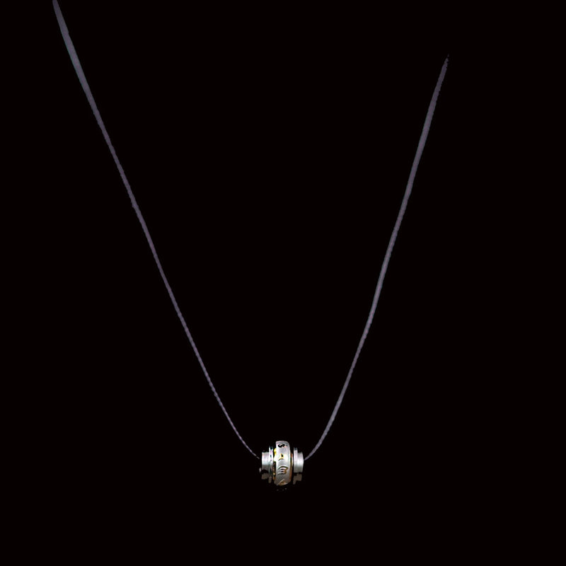 Silver pendant necklace with a cylindrical charm featuring ridged edges.