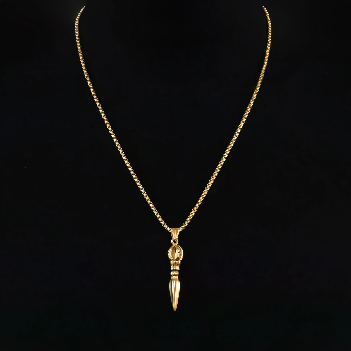 Gold necklace with a pointed pendant resembling a dagger or spike.