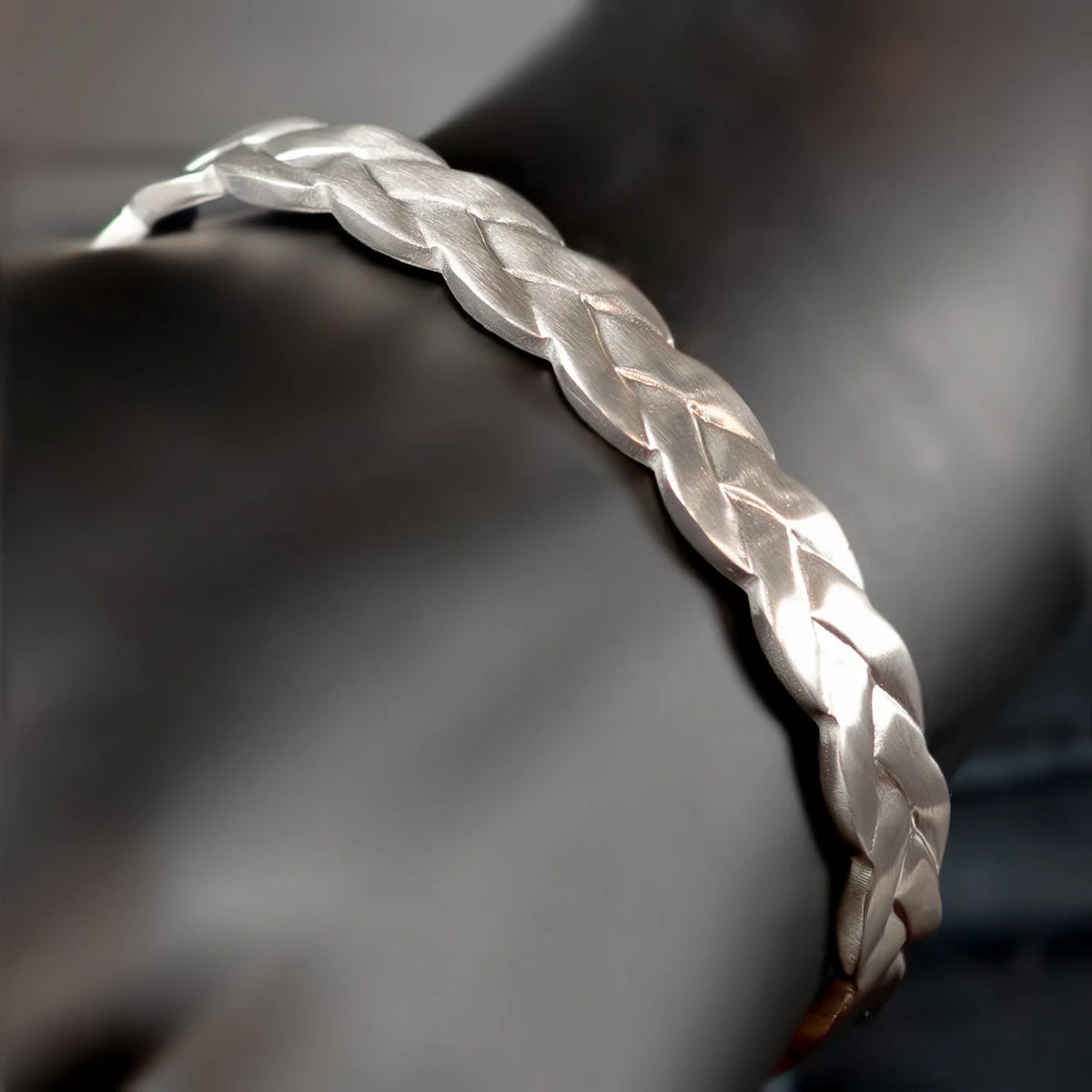 Silver braided bracelet with a woven pattern.