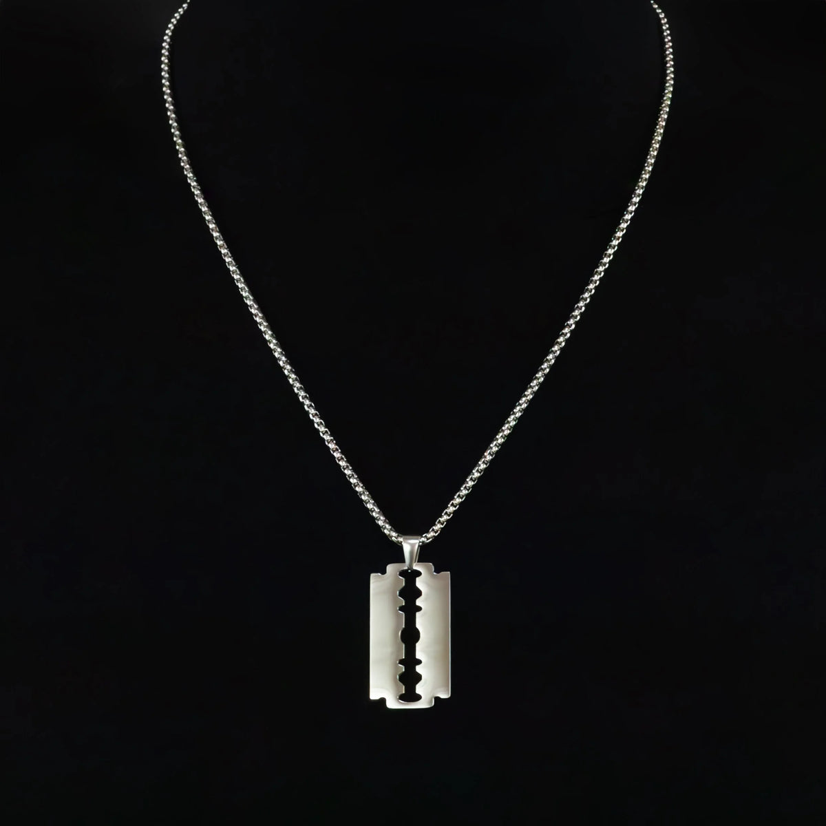 Razor blade pendant necklace on a silver chain.