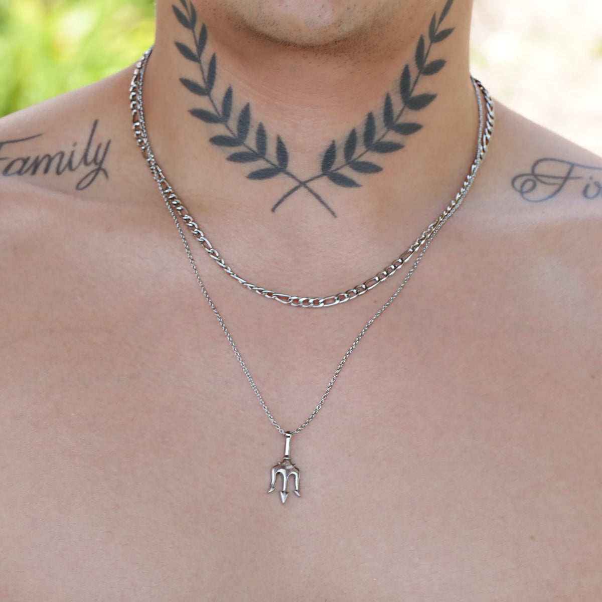 Silver layered necklace with a pendant and laurel wreath neck tattoo.