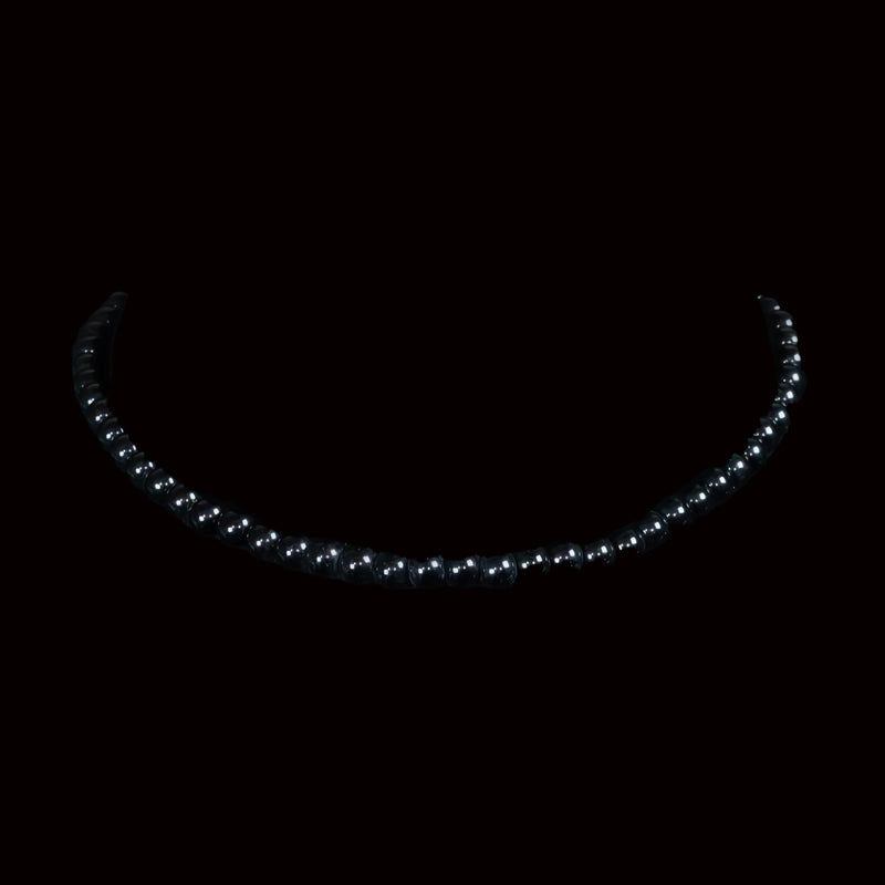 Curved string of glowing white lights against a dark background.